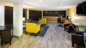 Een moderne woonkamer met een bank, een gele fauteuil en een eethoek met een tafel en stoelen.