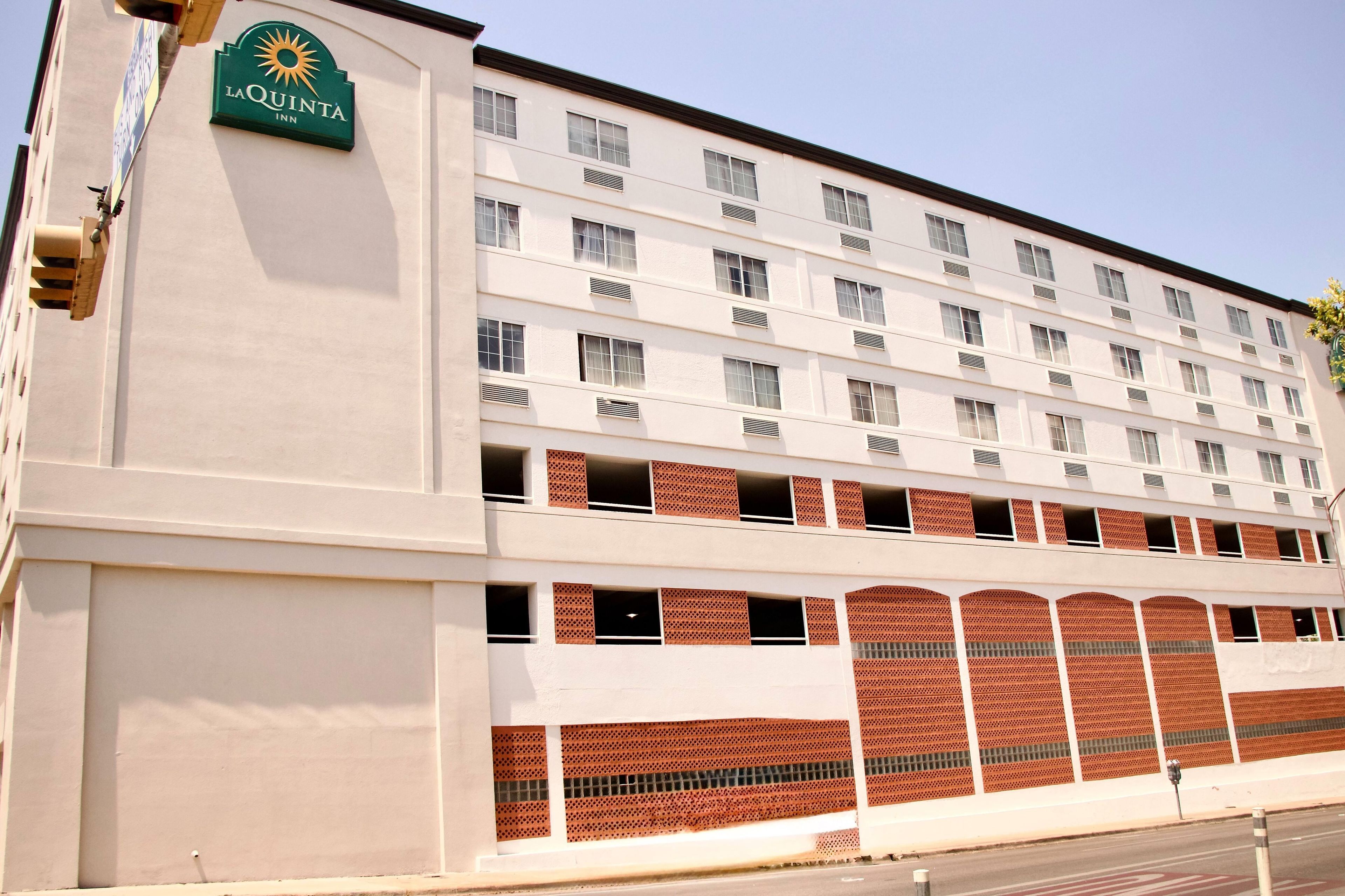 A multi-story hotel building with a prominent sign for La Quinta Inn.
