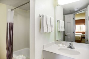A bathroom with a white sink, a mirror, and a shower curtain. - La Quinta Inn by Wyndham Austin Capitol / Downtown (Austin)