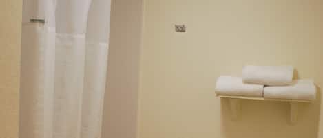 Un baño con inodoro, cortina de ducha y toallero.