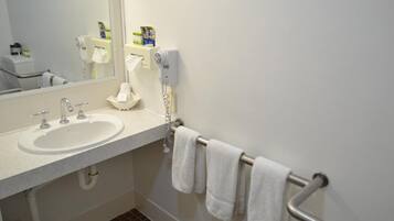 A bathroom with a sink, mirror, towel rack, and a hand dryer.