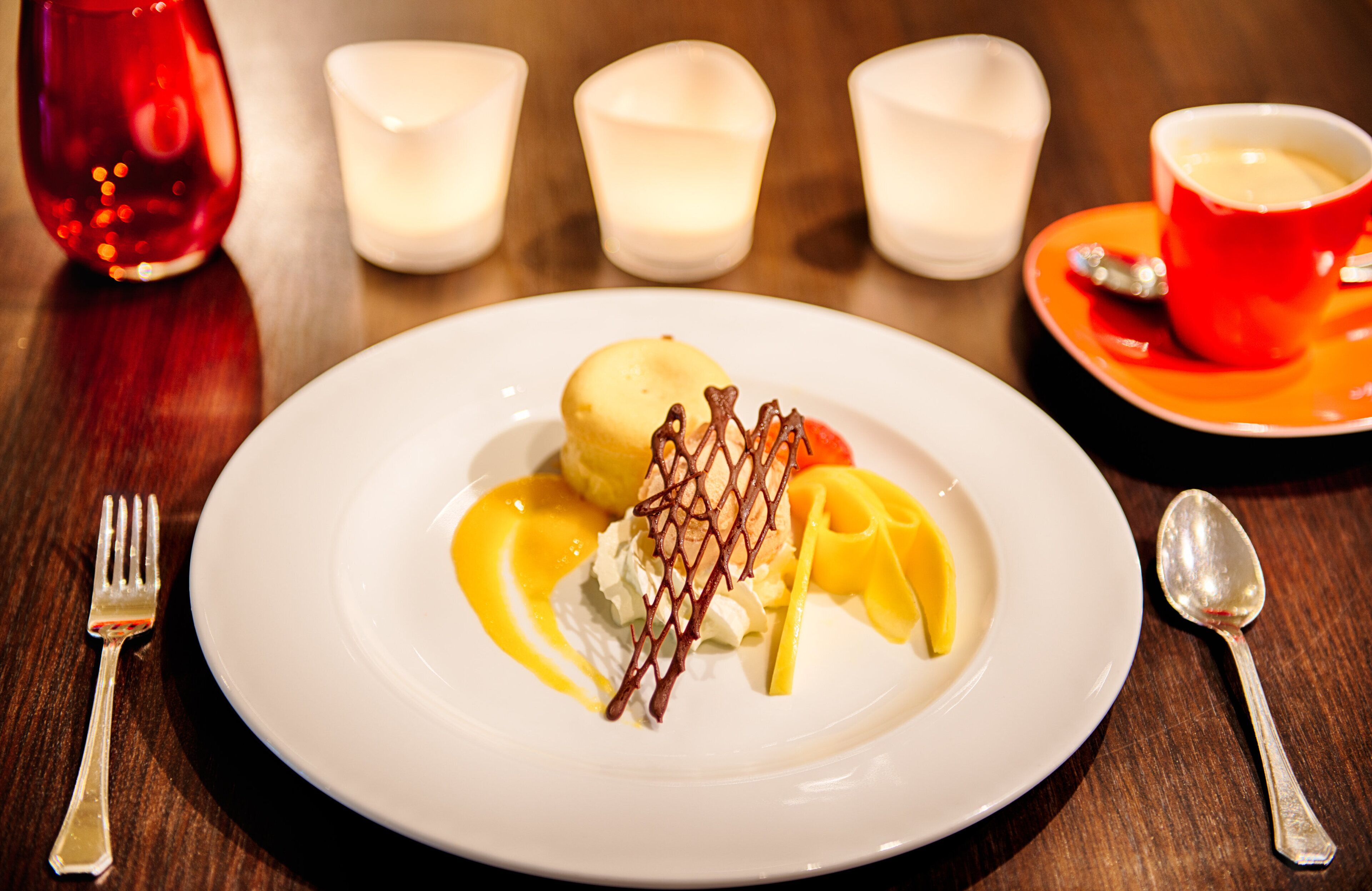 Un plato de postre con una porción de helado, un hilo de salsa y decoraciones de chocolate sobre un plato blanco.