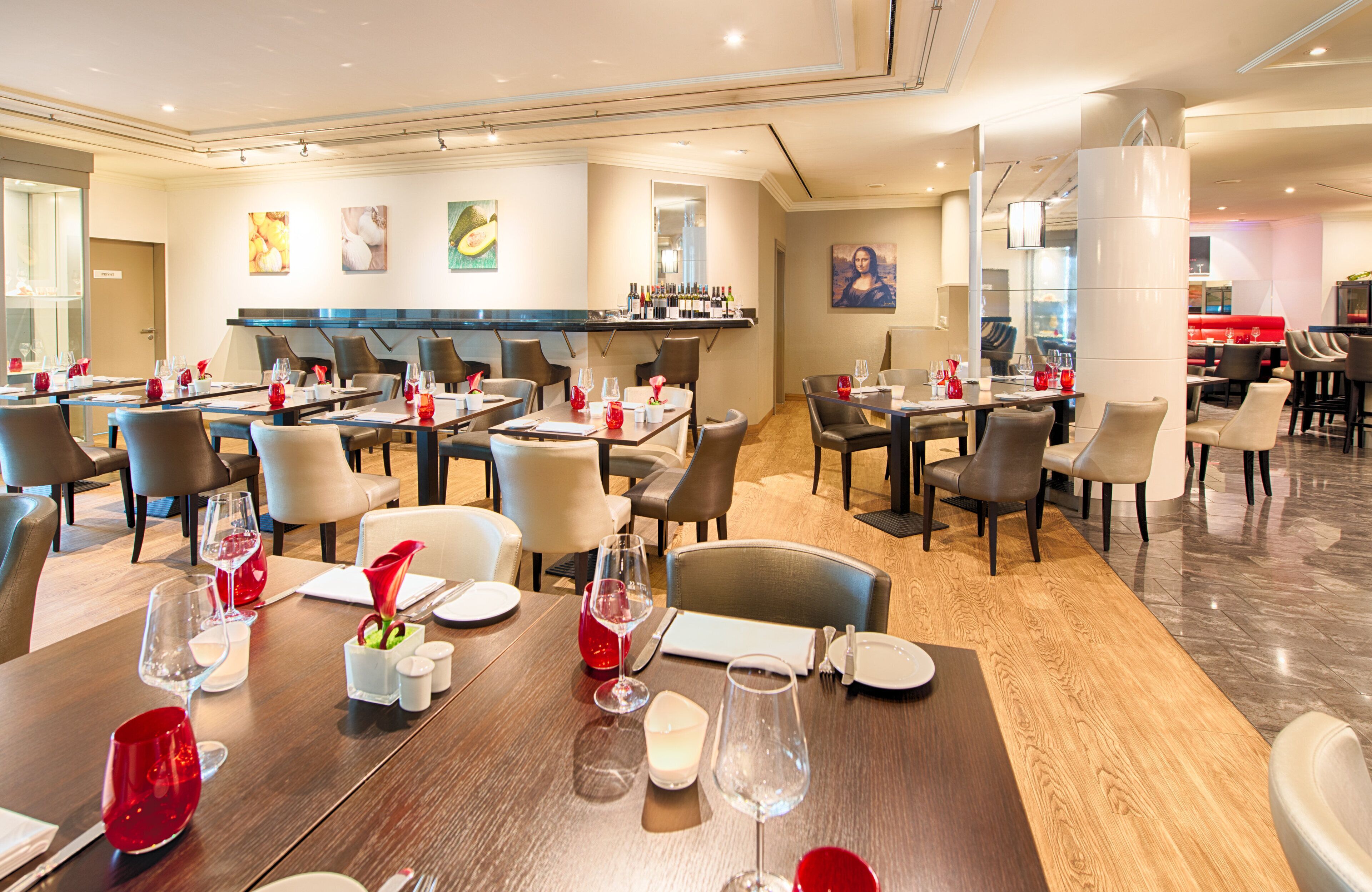 Un restaurante con varias mesas, sillas y una zona de bar.