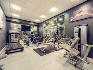 A gym with treadmills, weight machines, and exercise balls.