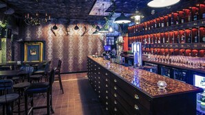 A bar area with a counter, stools, and a wall of liquor bottles. - Nottingham City Centre by Sunday (Nottingham)