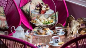 A tiered tray with various pastries and sandwiches, a teapot, cups, and a decorative skull. - Nottingham City Centre by Sunday (Nottingham)