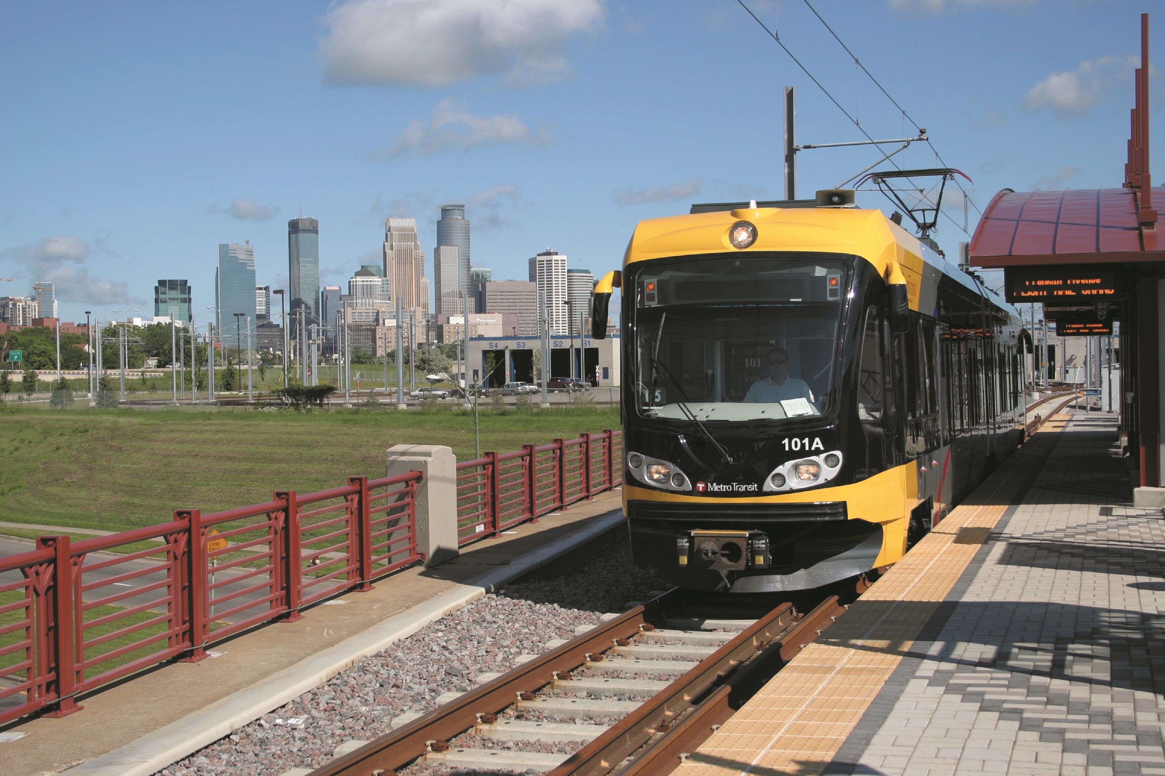 Een trein op een station met een stadsachtergrond.
