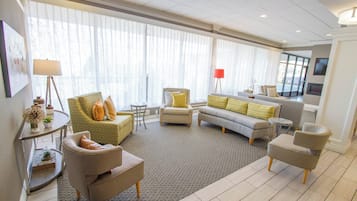 Un amplio espacio de sala con un sofá, sillones, una mesa de centro y una mesa de comedor.