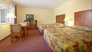 A hotel room with two beds, a desk, a television, and a dresser. - Relax Inn And Suites (El Cajon)