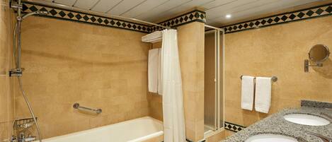 Un baño con bañera, dos lavamanos y ducha.