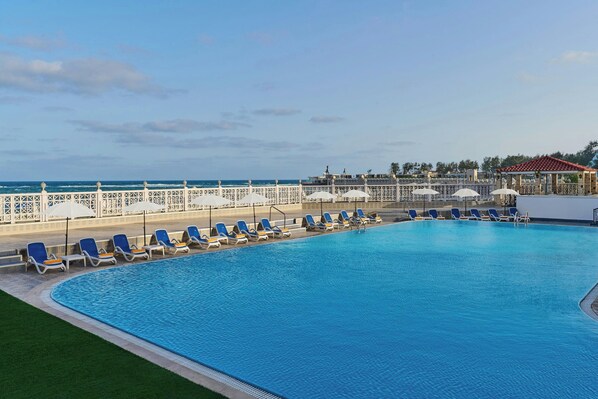 Alberca al aire libre, sombrillas en la alberca y camastros 