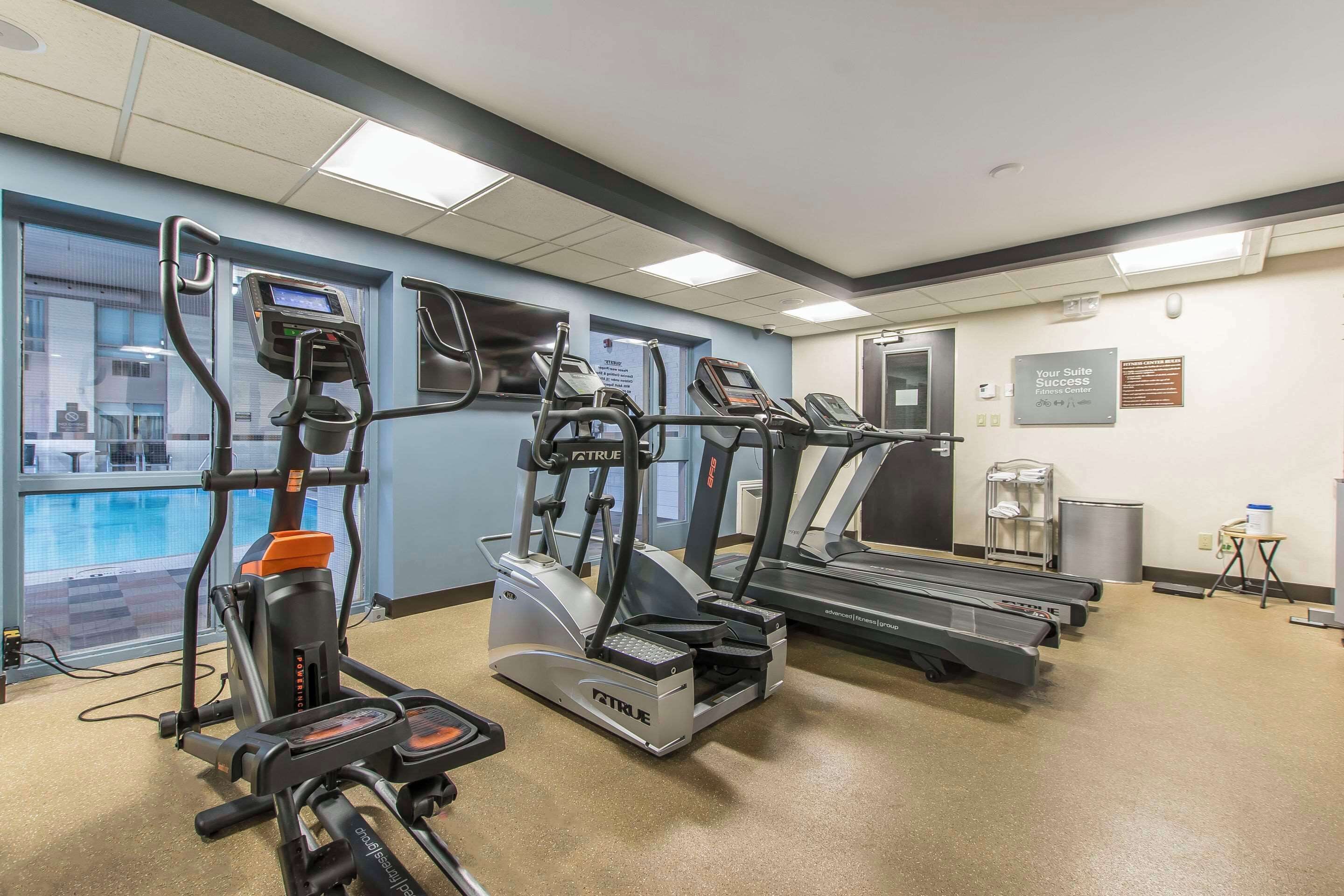 A fitness center with treadmills, ellipticals, and a stationary bike, equipped with digital displays.