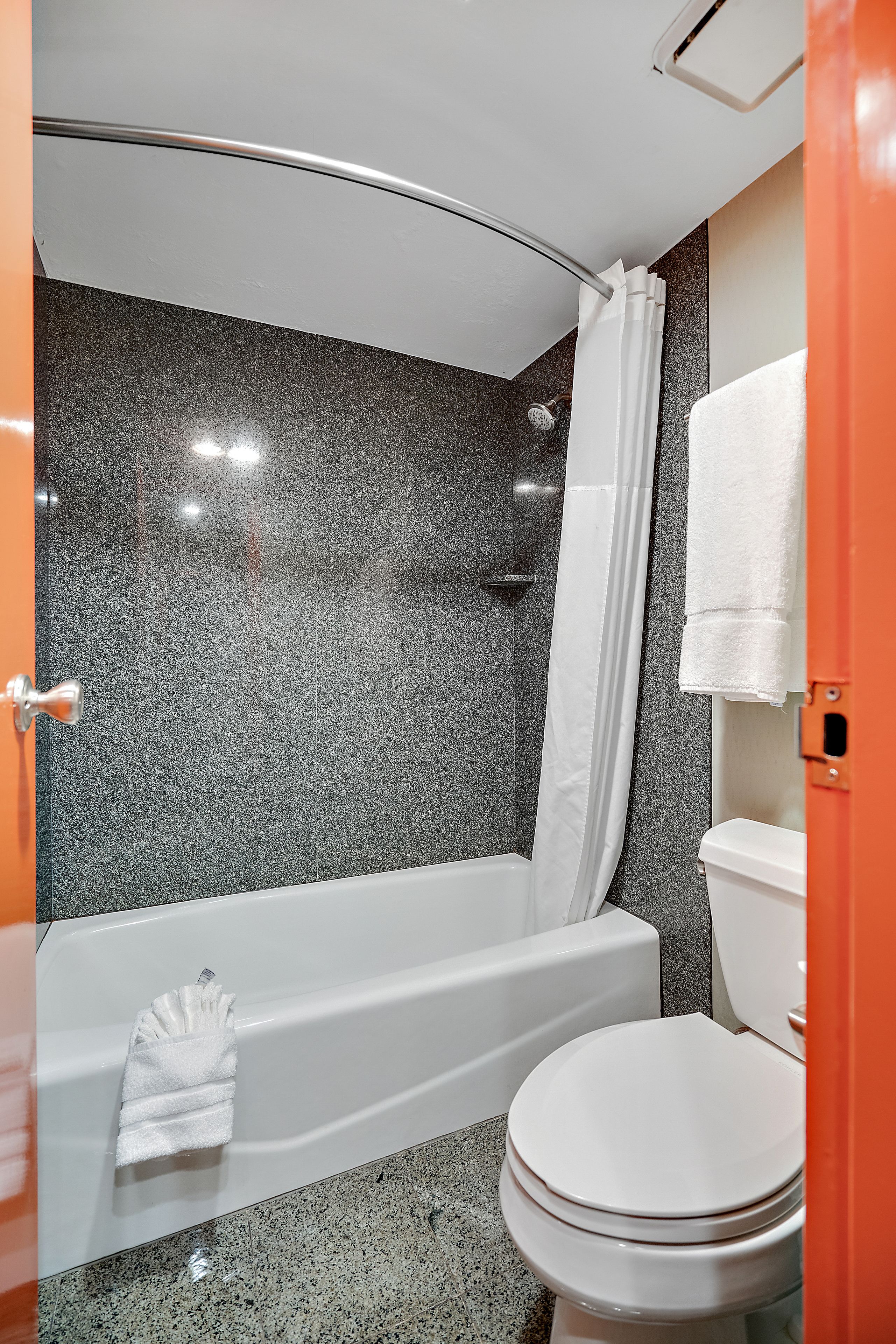 A bathroom with a shower, toilet, and bathtub.