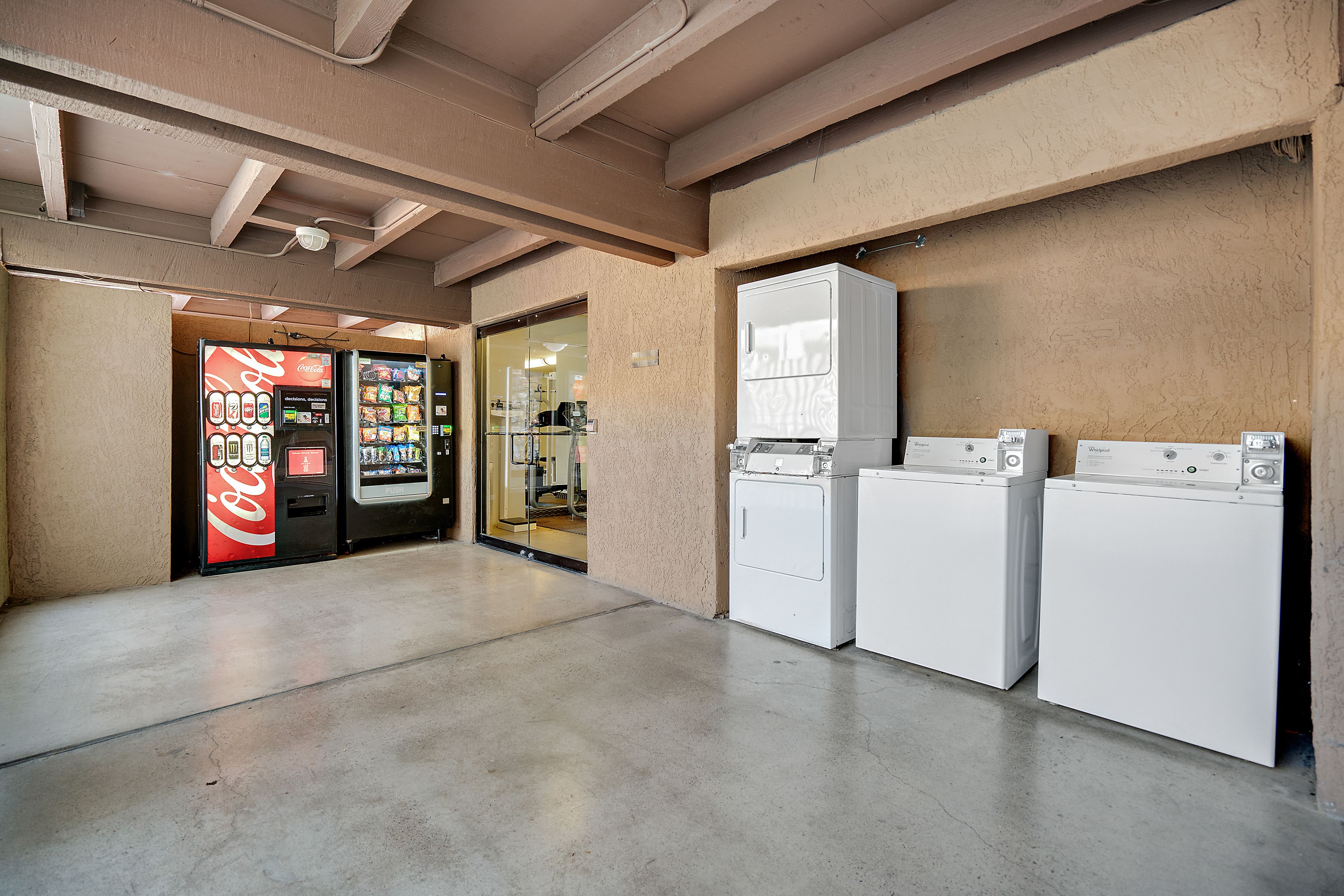 Zona de bugaderia amb dues rentadores i una màquina expenedora de Coca-Cola.