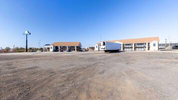 A Days Inn with a large parking lot and a building with a brown roof.