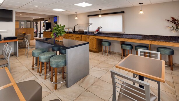 A modern kitchen area with a bar counter, stools, and a large island with bar stools.