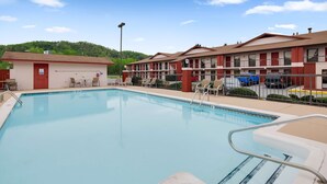 A swimming pool with lounge chairs and a small building, likely a changing room or storage, adjacent to it.