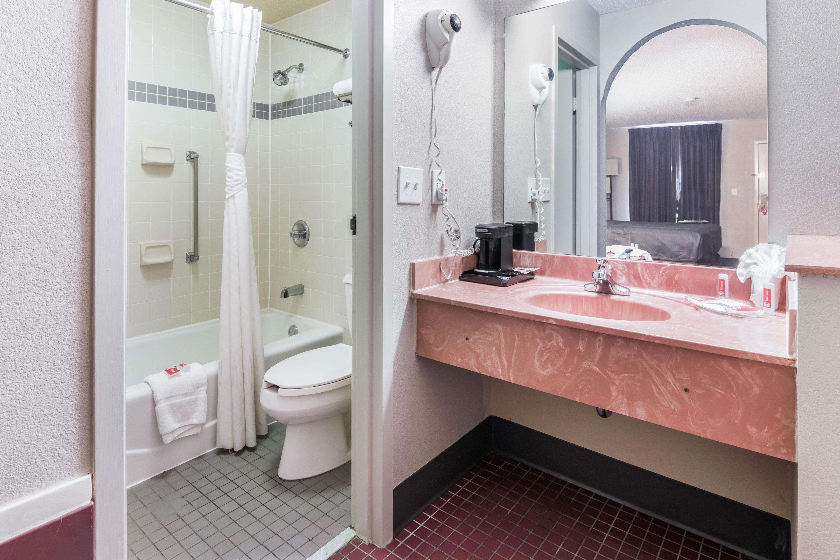 A bathroom with a shower, toilet, and sink.