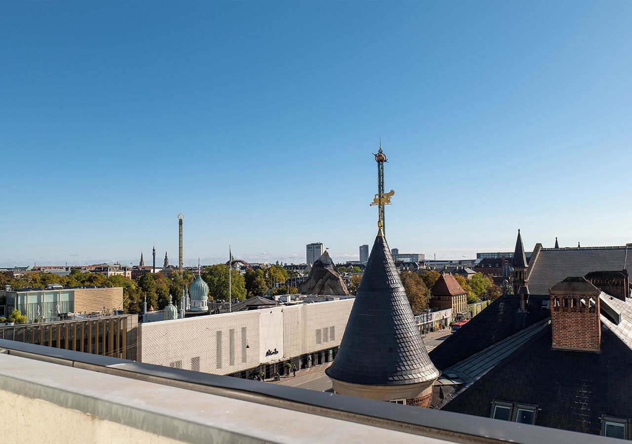 Un paysage urbain caractérisé par un clocher d’église imposant, un bâtiment moderne et un mélange d’architecture traditionnelle et contemporaine.