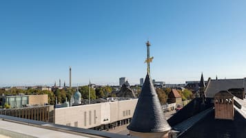 Un paysage urbain caractérisé par un clocher d’église imposant, un bâtiment moderne et un mélange d’architecture traditionnelle et contemporaine.