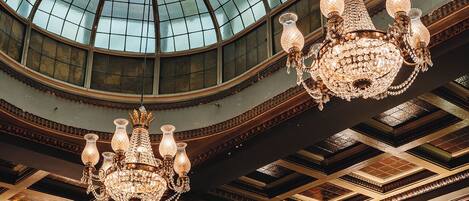 Un salón amplio con un gran techo abovedado de vidrio y candelabros ornamentales.