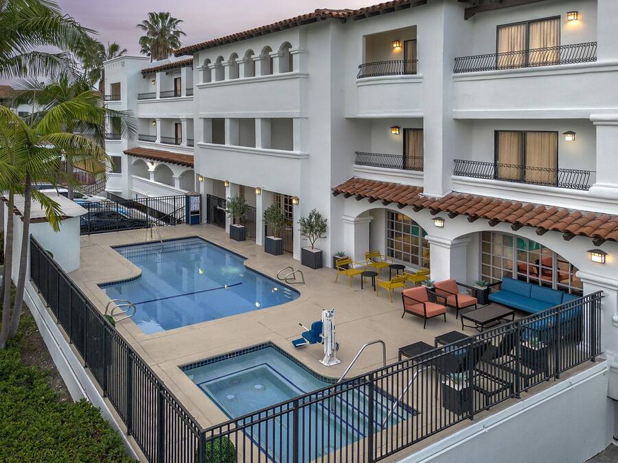 Un hôtel doté d’une piscine sur le toit, d’un espace extérieur aménagé et de plusieurs balcons.
