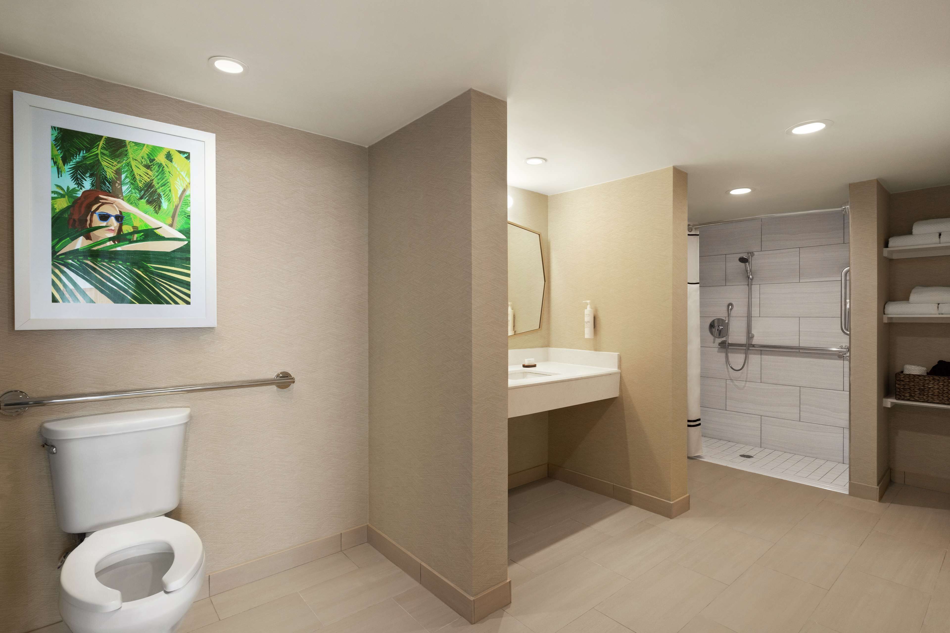 A modern bathroom with a toilet, sink, and shower.