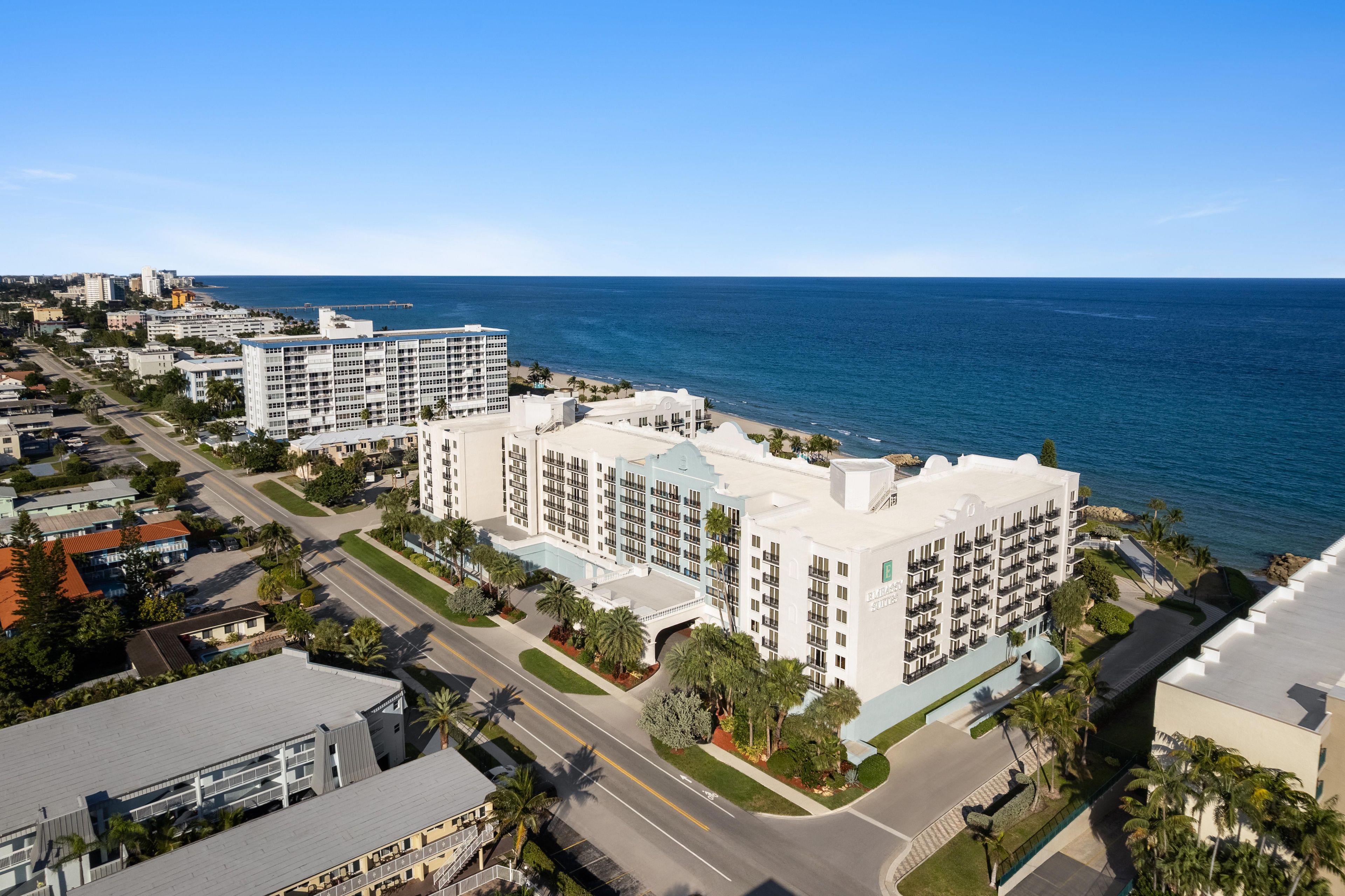 A high-rise hotel with multiple floors, a central courtyard, and a view of the ocean.