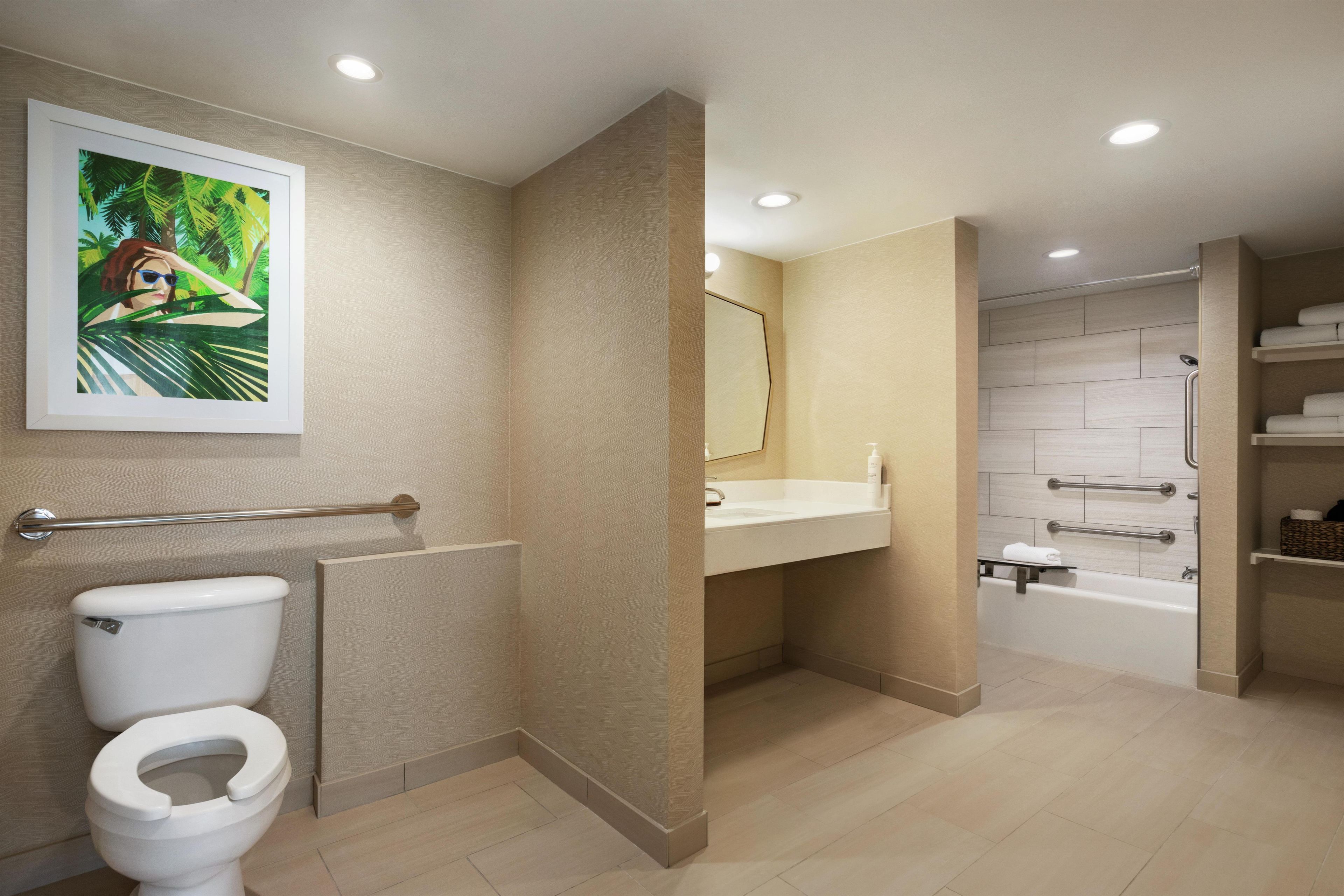 A modern bathroom with a toilet, sink, and bathtub.