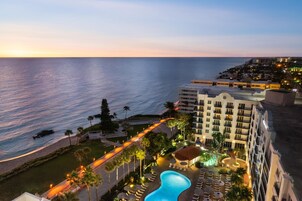 Una piscina al aire libre, sombrillas, sillones reclinables de piscina