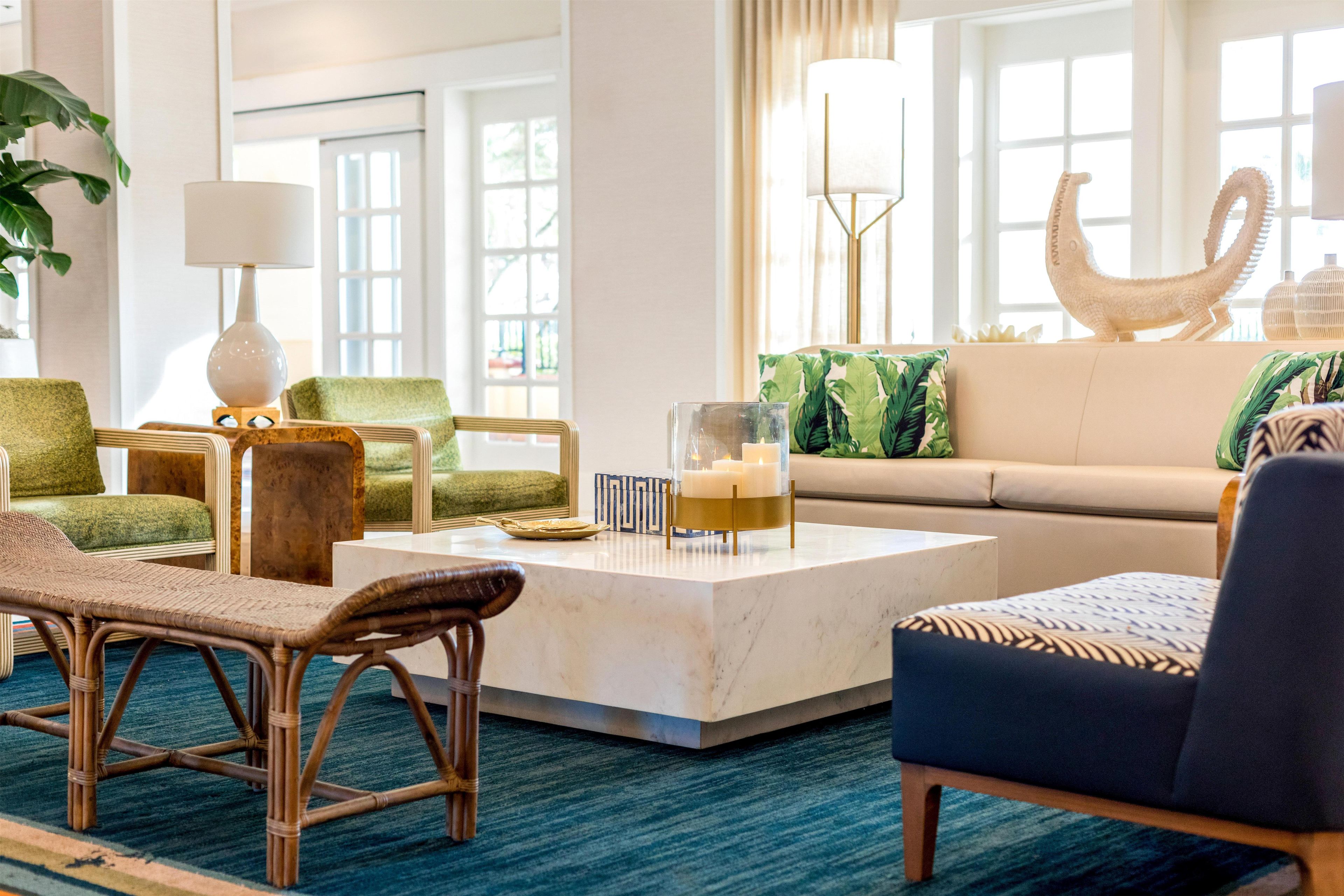 A well-lit living room with a sofa, chairs, a coffee table, and a decorative sculpture.