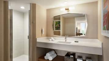 A modern bathroom with a shower, a sink, and a mirror.