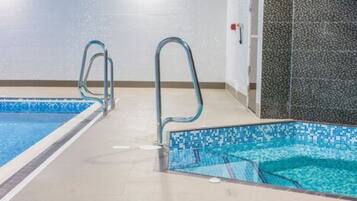 Two pools offer a refreshing oasis with tile patterns and metal handrails for safety.