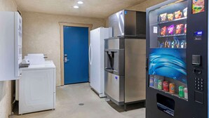 A compact hotel room with a washing machine, a refrigerator, and a vending machine. - Best Western Hanford Inn (Hanford)