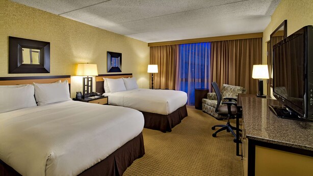 A hotel room with two beds, a desk with a TV, and a chair. - DoubleTree by Hilton Chicago - Arlington Heights (Arlington Heights)