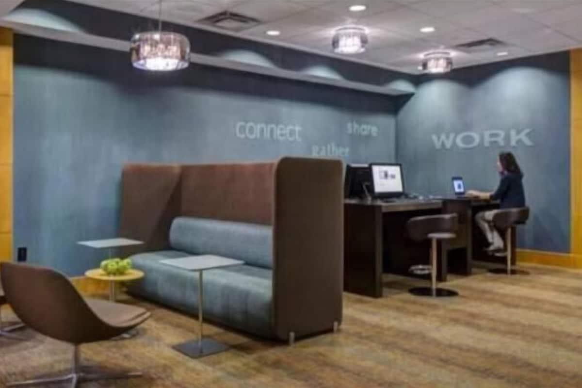 A modern workspace with a sofa, chairs, and a desk area.