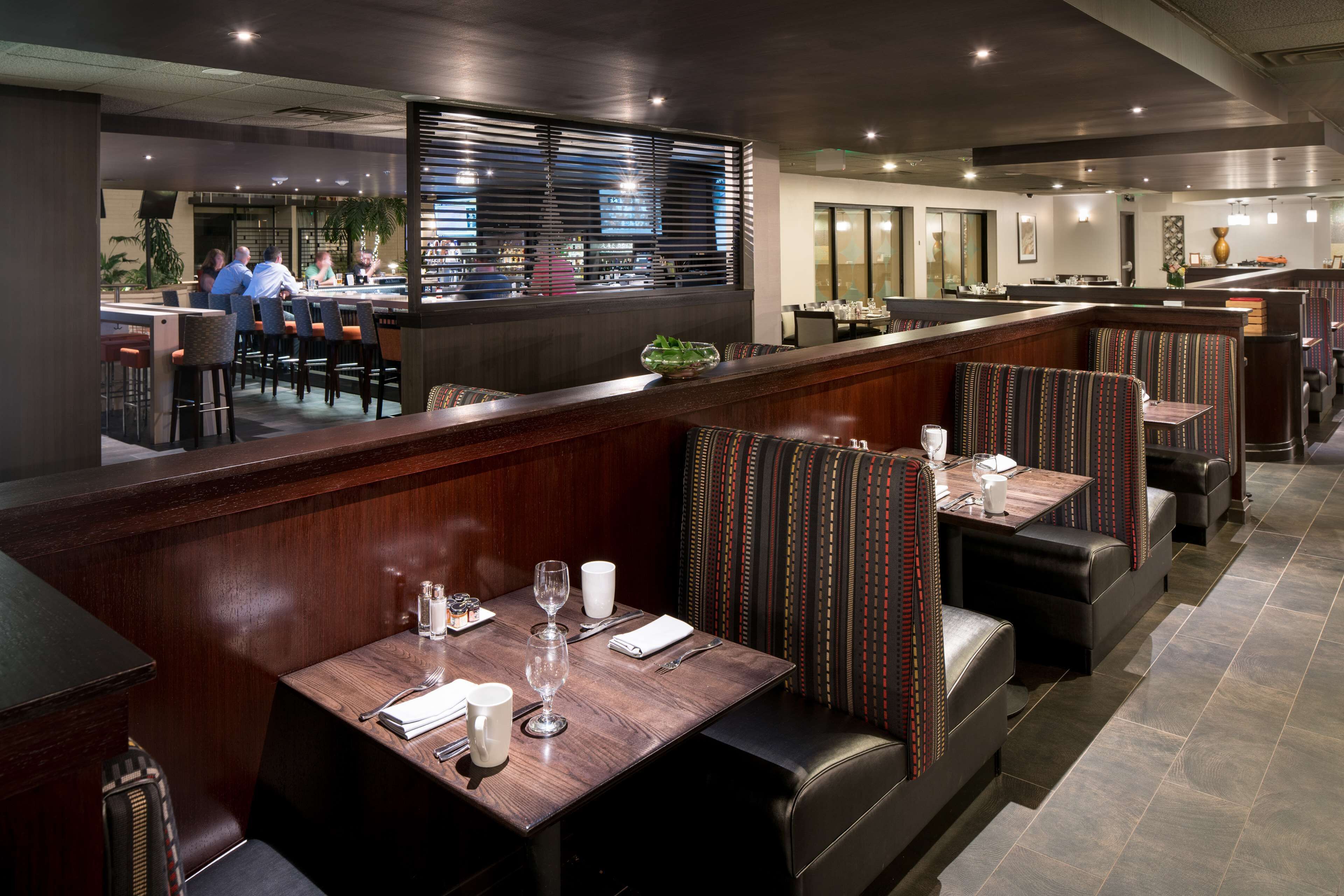 A restaurant with booths and high tables, a bar area, and a view of the street.
