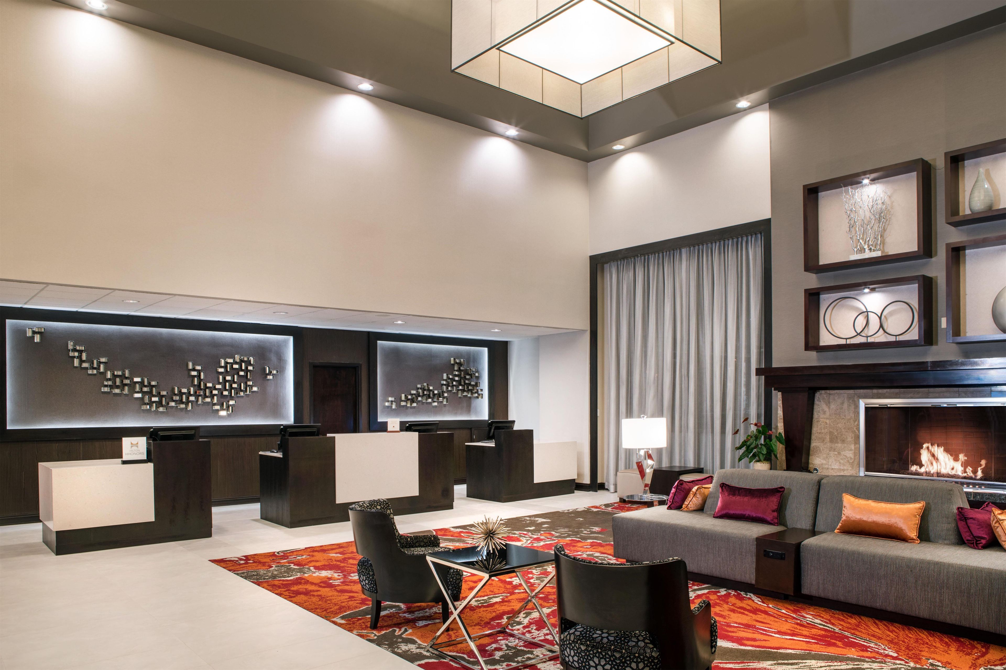 A modern living room with a fireplace, seating area, and artwork on the walls.