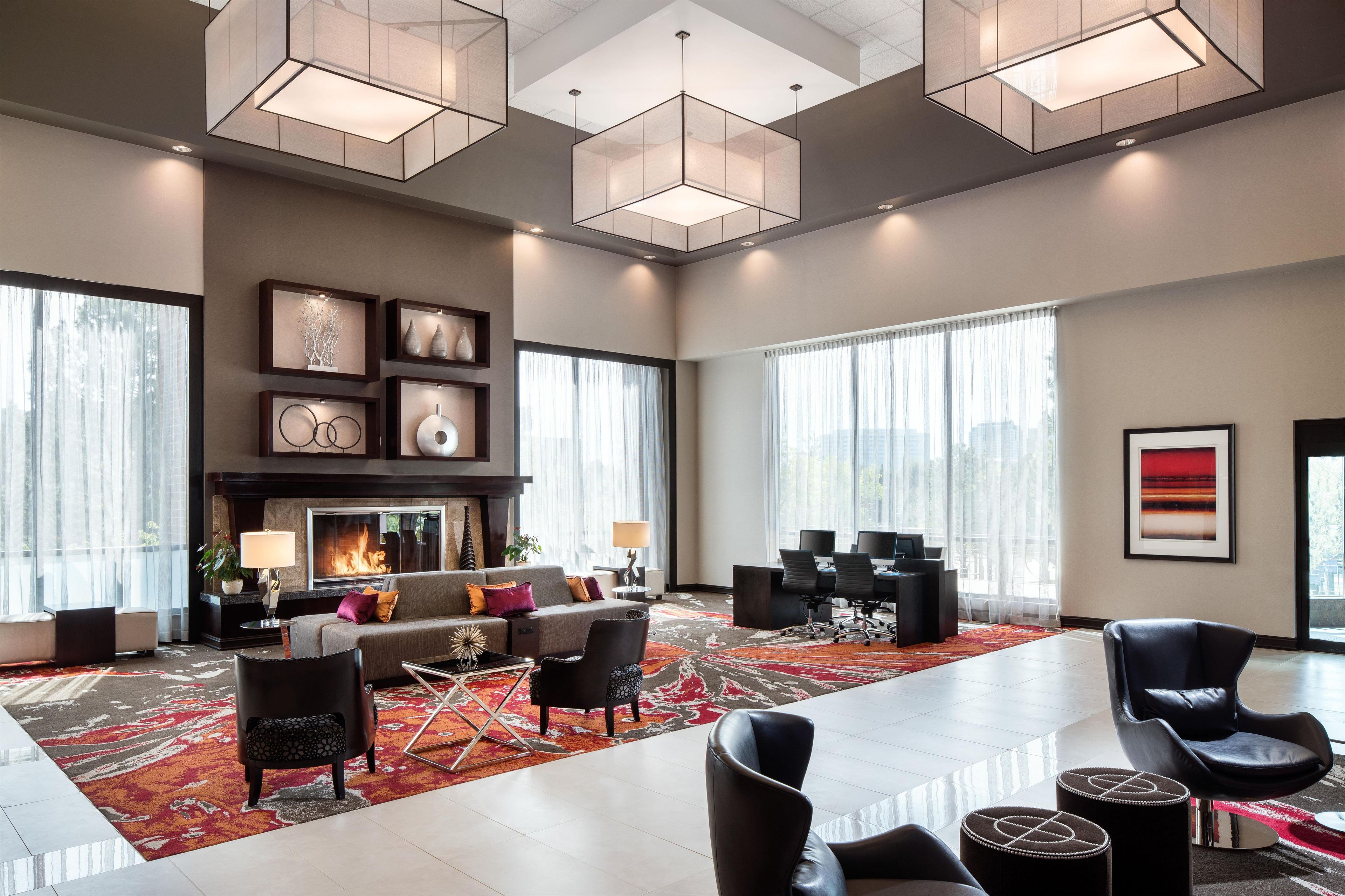 A spacious living area with a fireplace, modern furniture, and large windows.