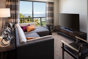 Une chambre d’hôtel moderne avec un canapé, une télévision et une vue sur les montagnes.