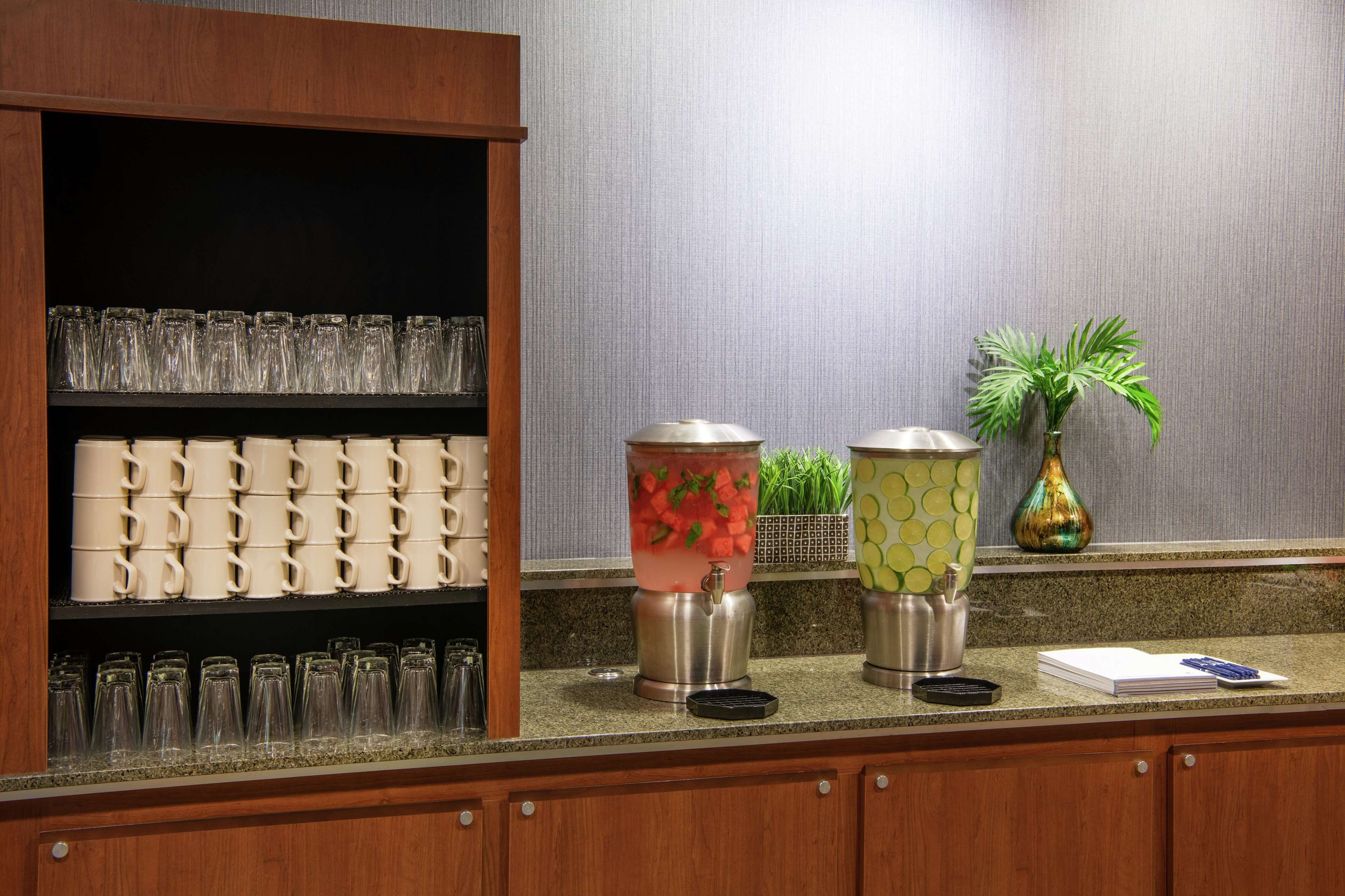 A kitchen counter with a coffee machine, a blender, and a potted plant.