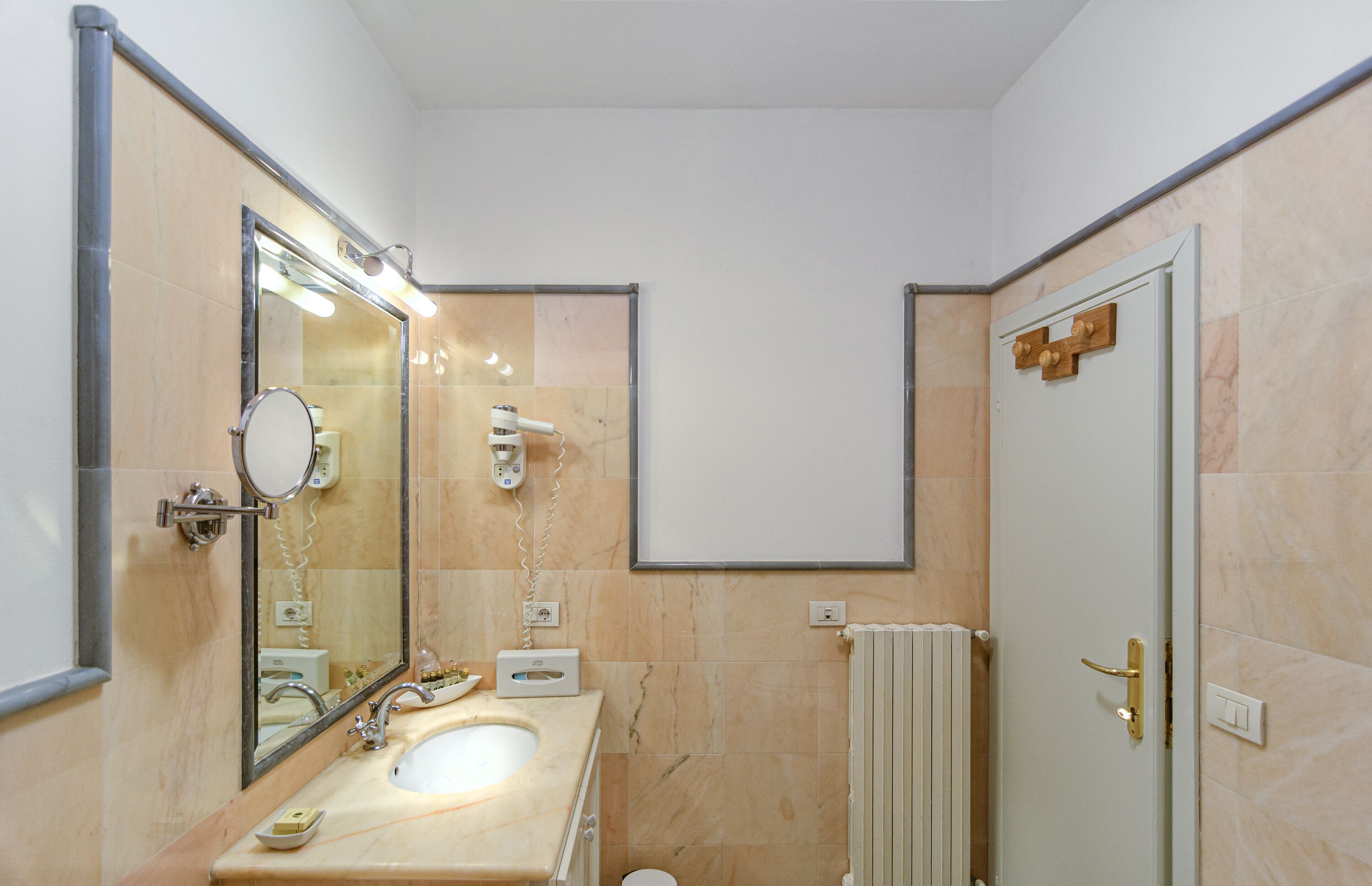 Un bagno con lavandino, specchio e doccia.