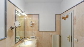 Un bagno con lavandino, specchio e doccia.
