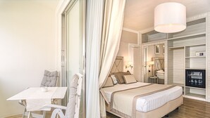 A hotel room with a bed, a table, a chair, a wardrobe, and a bathroom. - Raffaelli Park Hotel (Forte dei Marmi)