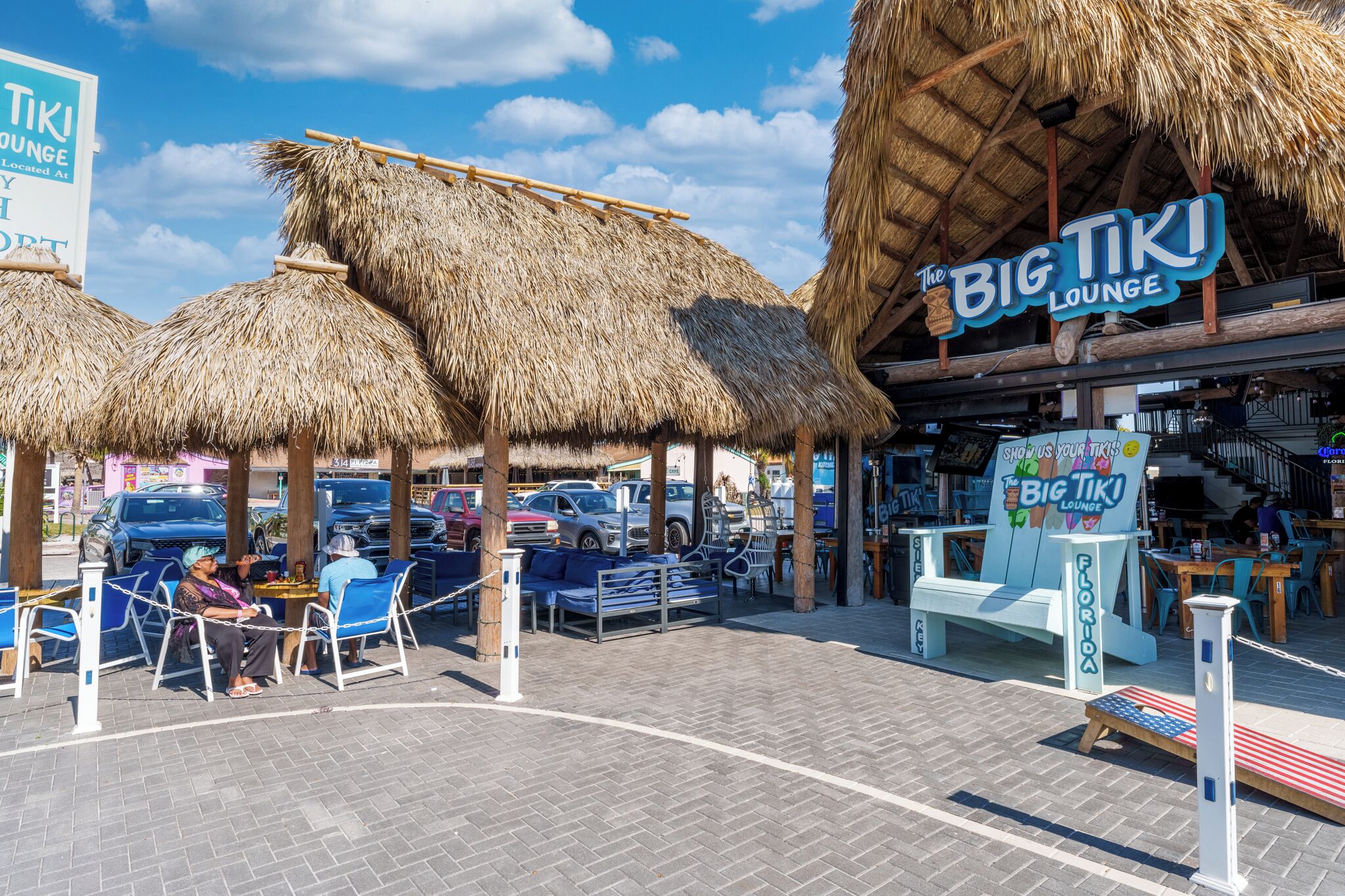 Un'area lounge tiki con tetti di paglia e posti a sedere all'aperto.