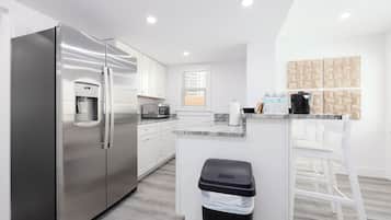 Una cucina moderna con un frigorifero in acciaio inossidabile, un forno a microonde e un erogatore d'acqua.