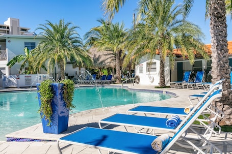 Una piscina al aire libre, sillones reclinables de piscina
