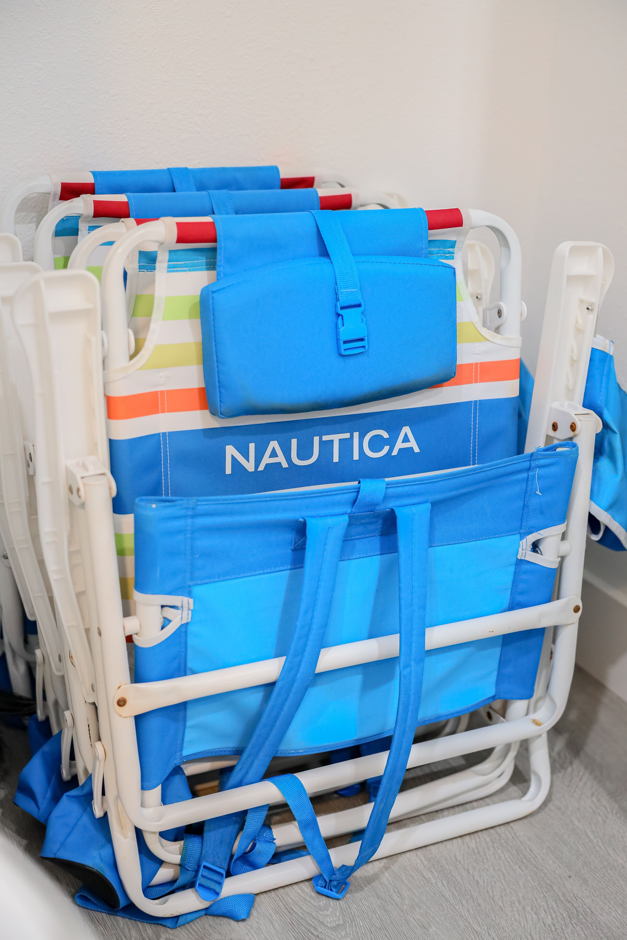 En vagn med blått och vitt bagage, inklusive en blå väska med texten ”NAUTICA” på.