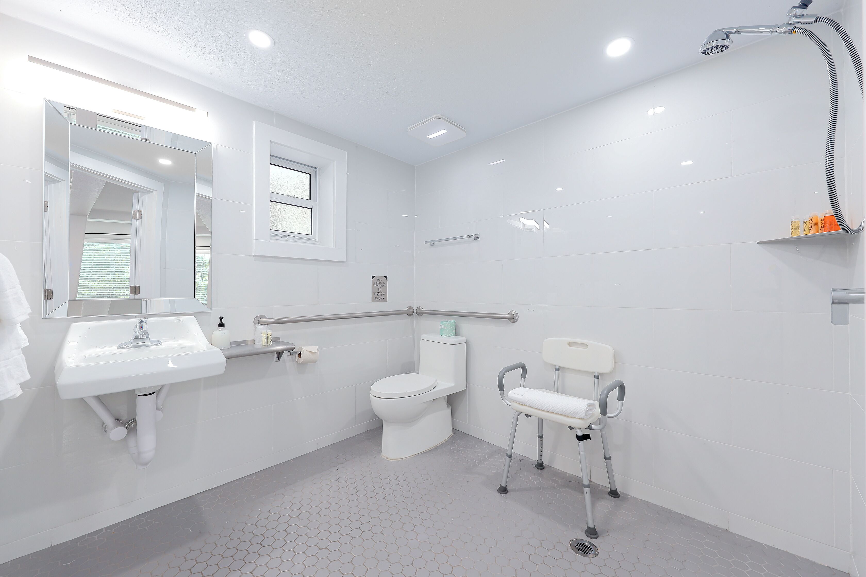 Un baño moderno con lavamanos, inodoro y ducha blancos.