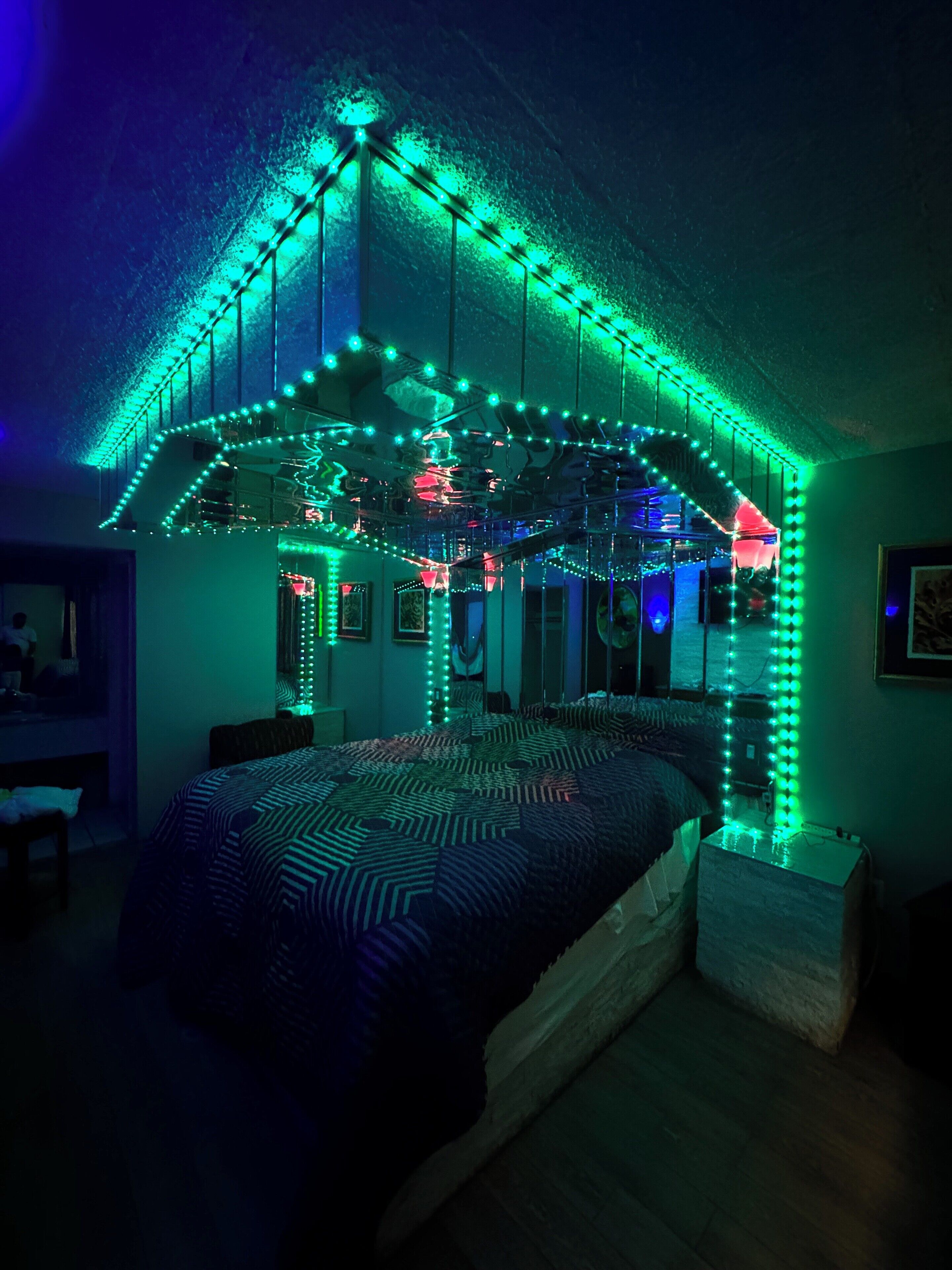 A bedroom with a bed, a dresser, and a mirror.